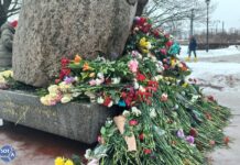 Петербуржцы продолжают возлагать цветы к Соловецкому камню в Санкт-Петербурге