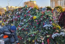 Закрытие Борисовского кладбища не помешало кресту Алексея Навального скрыться под цветами: пришедшие продолжают бросать цветы через забор