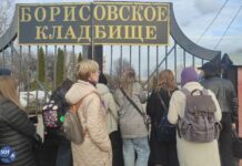 Пришедшие почтить память Алексея Навального на его сороковины передают цветы через забор работникам Борисовского кладбища