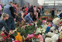 Народный мемориал у «Крокуса» частично восстановили и перенесли на газон. Люди продолжают нести цветы «по разнарядке» и не только