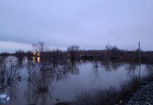 В Орске засыпают прорыв в дамбе. По словам рабочих, это должно остановить поток воды