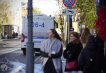 К дому Политковской в годовщину ее убийства подъехал автозак. Полицейские останавливают людей с цветами